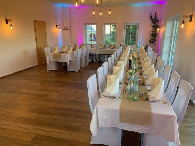 Saal der Pizzaheros mit langer Tafel, eingedeckt für eine Feier